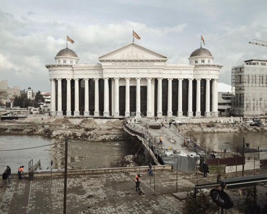 Teren budowy Muzeum Archeologicznego Macedonii, w którym znajduje się kopia tzw. „sarkofagu Aleksandra”. Nabycie tego pomnika-grobowca wywołało żywą debatę wśród opinii publicznej, jako że nie da się go jednoznacznie powiązać z Aleksandrem Wielkim, a na temat jego pochodzenia istnieje bardzo wiele teorii. Po tym jak szczątki władcy zniknęły z Egiptu w 323 roku p.n.e., jego ostateczne miejsce spoczynku nie zostało nigdy odkryte. A jednak, mimo niepewnego pochodzenia, dokładna kopia tego dzieła została umieszczona w specjalnej komorze, zwieńczając kolekcję zgromadzoną ku pamięci tego rzekomego przodka współczesnych Macedończyków. Skopje, 2013 (źródło: dzięki uprzejmości artysty)