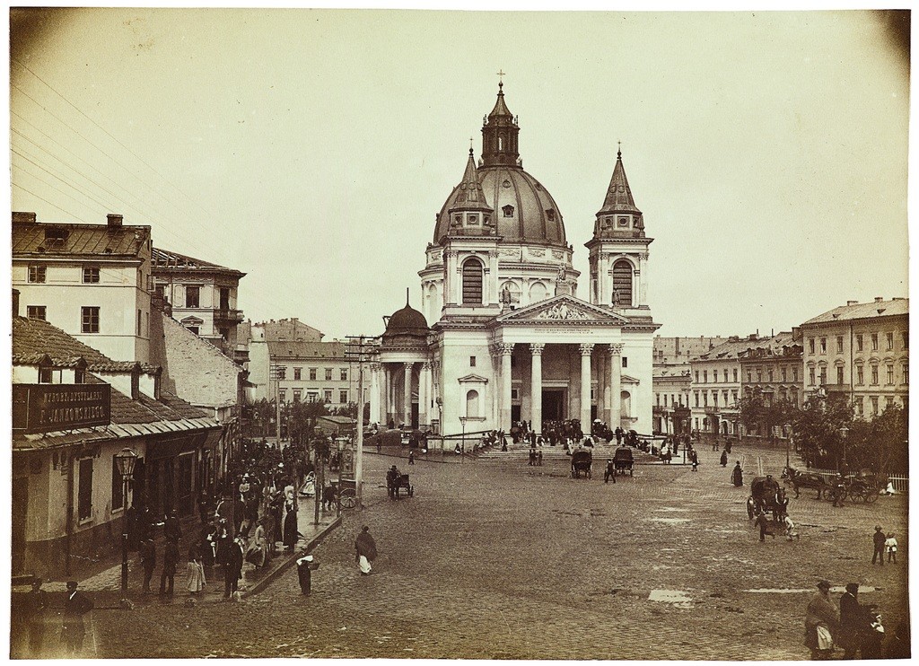 Kościół św. Aleksandra na placu Trzech Krzyży, ok. 1895. Fotografia wykonana w kierunku północnym. W centrum kościół przebudowany na przełomie lat 80. i 90. XIX w. przez Józefa Piusa Dziekońskiego. Monumentalna świątynia została zburzona w czasie II wojny światowej. Po wojnie odbudowana wg projektu Aignera. Fot. Konrad Brandel/ Muzeum Narodowe w Warszawie (źródło: materiały prasowe)