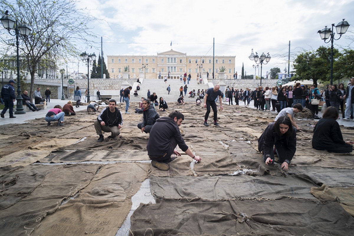 Ibrahim Mahama, „Check Point Prosfygika. 1934–2034. 2016–2017, 2017”, performance with charcoal sacks on Syntagma Square, Athens, documenta 14, fot: Mathias V­ölzke (źródło: materiały prasowe organizatora)