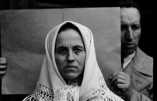 Autor nieznany, Fotografia twarzy kobiety, za nią badacz IDO, ze zbiorów AUJ (źródło: materiały prasowe organizatora)